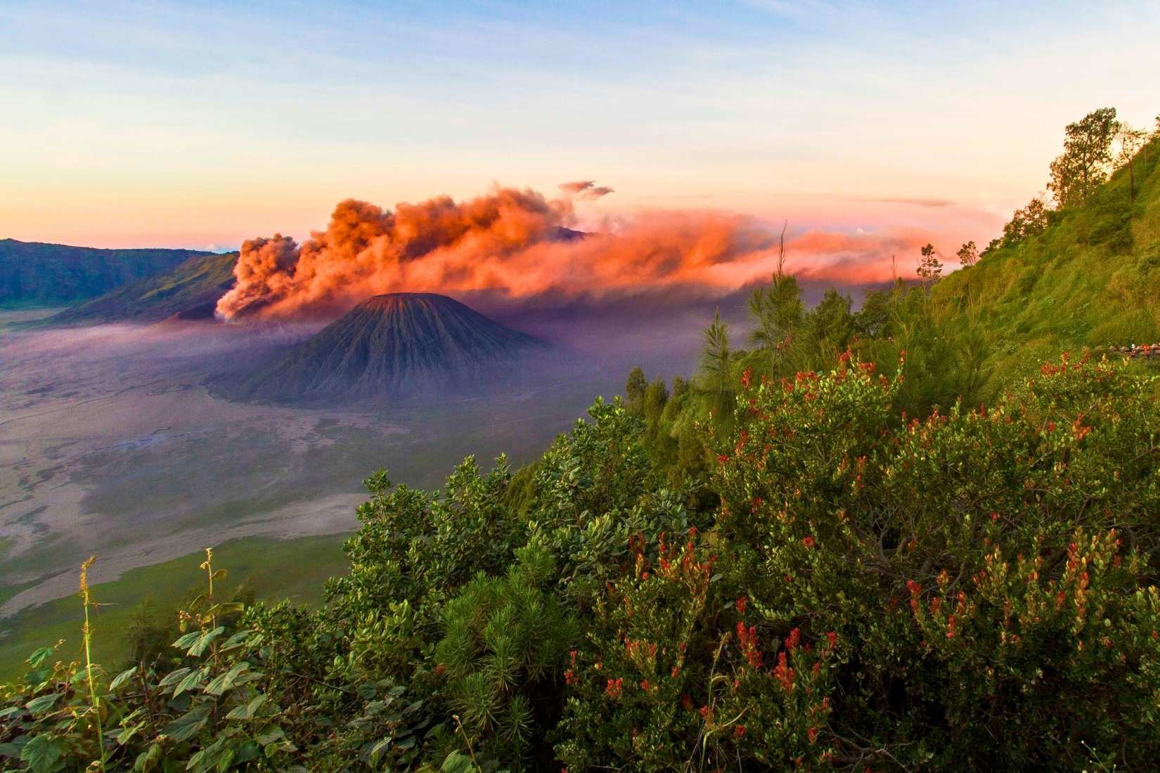 Photographer capturing sunrise at Mount Bromo viewpoint
