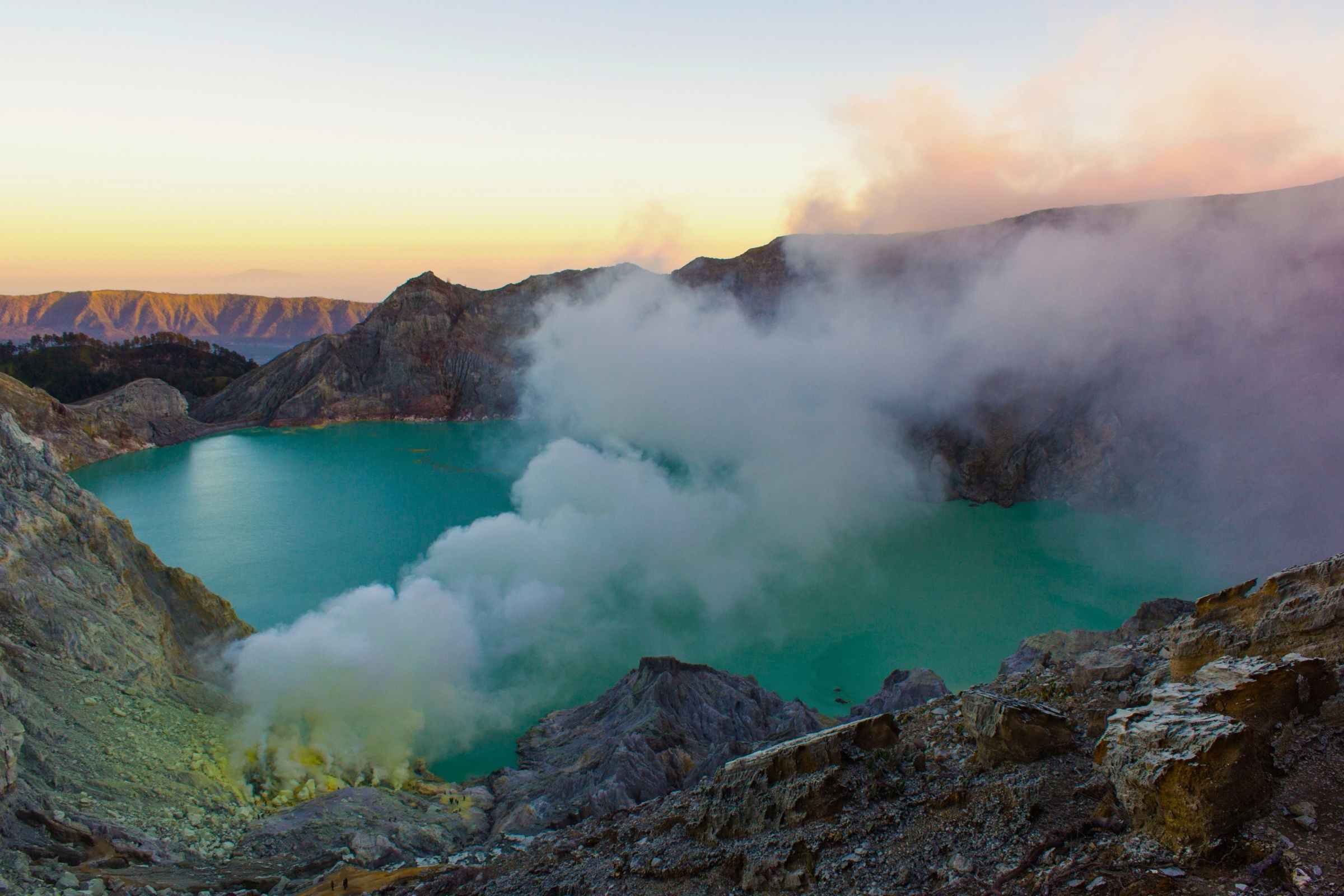 Ijen crater night hike leading to sunrise over turquoise acidic lake